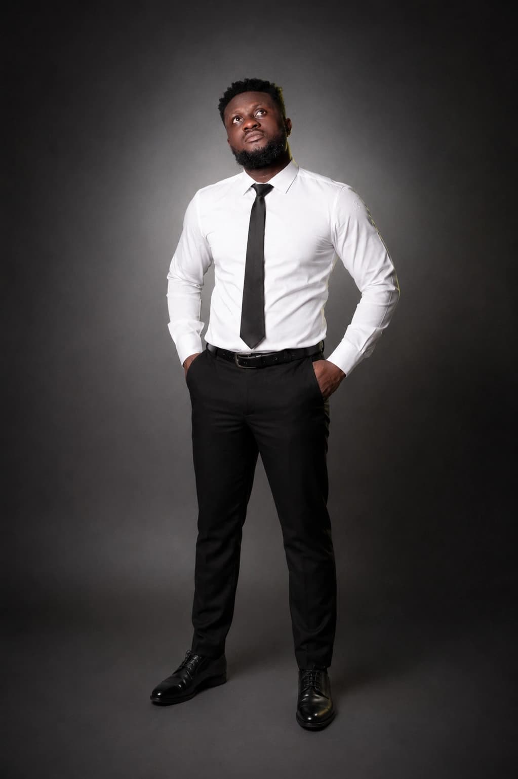 Full-length portrait of Ahn-TiYe in a white shirt and black tie